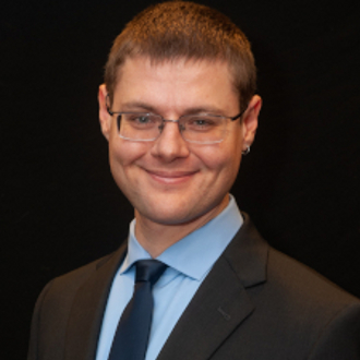Man in suit smiling for camera.