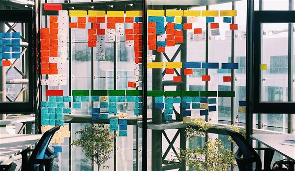 irfan-simsar-1144378-unsplash Conference room with dozens of sticky notes on the windows.