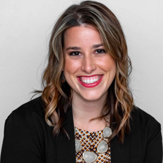 Woman dressed professionally and smiling for the camera.